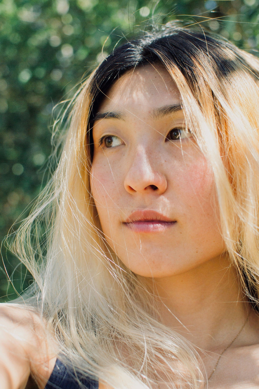 an asian woman with blonde beautiful hair in the nature 