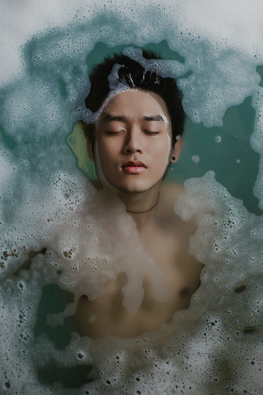 an asian man with clear face floating in the pool with the face up 