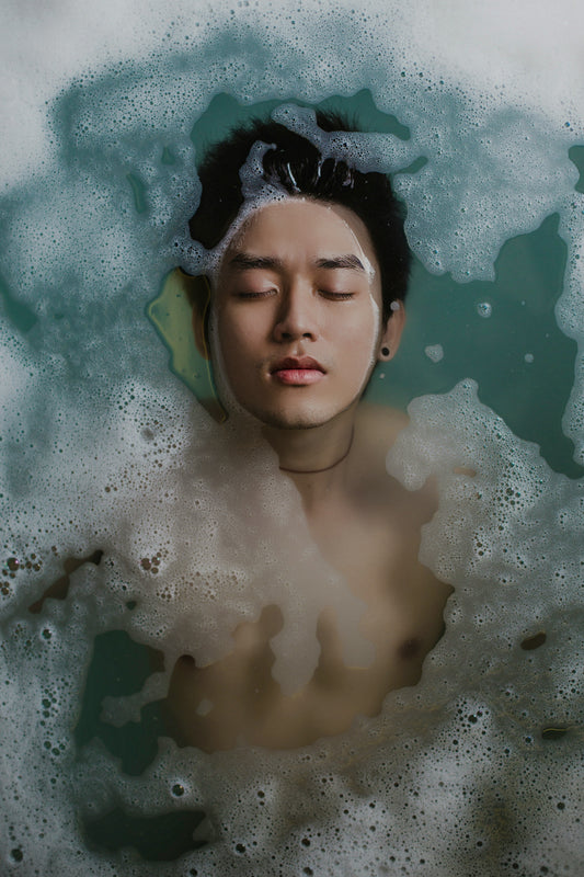 an asian man with clear face floating in the pool with the face up 