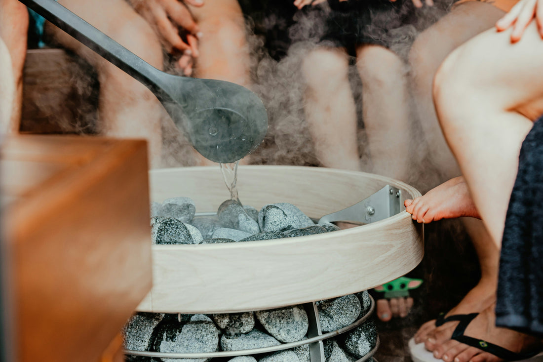 people sitting around the steaming sauna rocks 