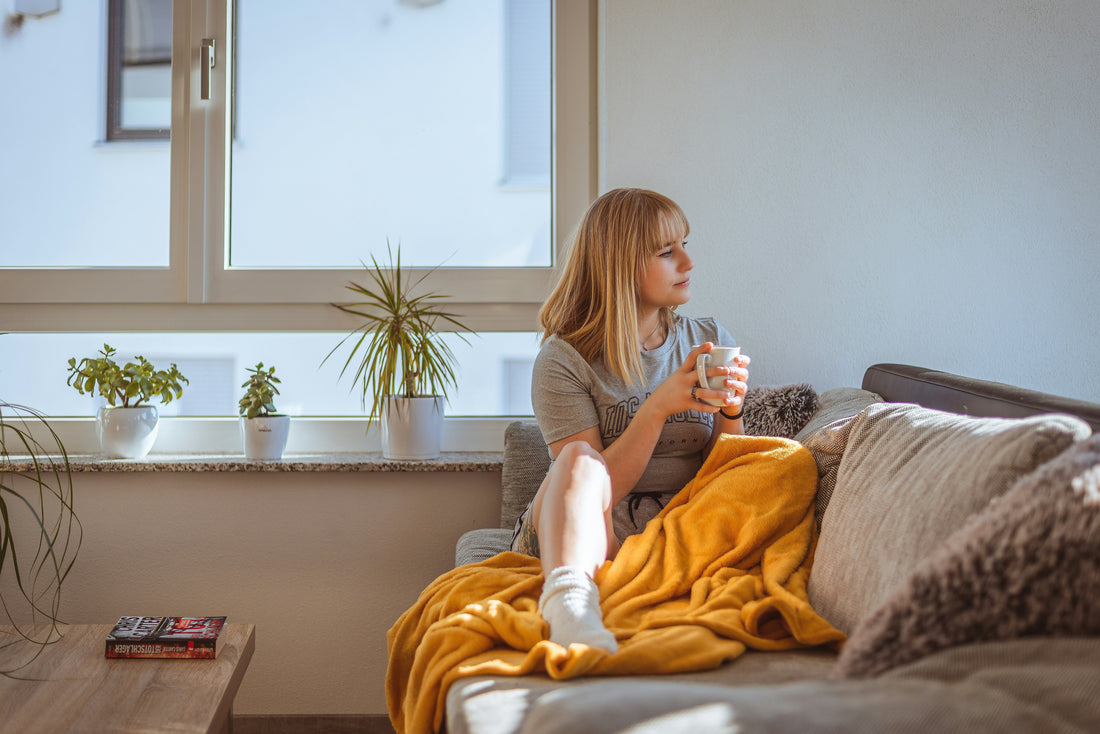 A blonde woman relaxing at home on the sofa 